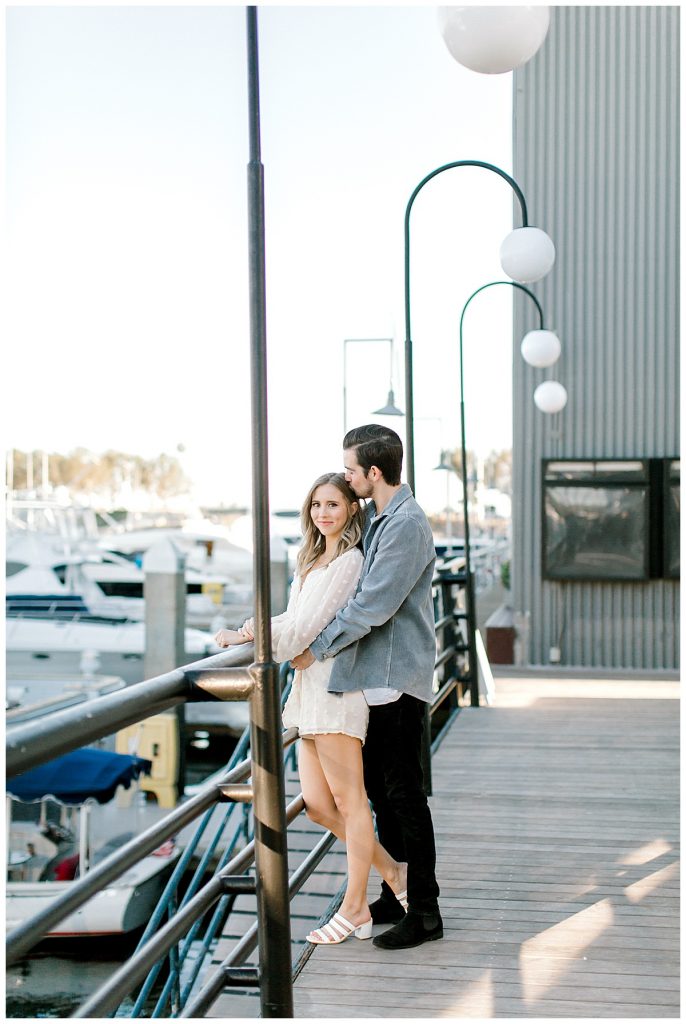 Couple leaning against railing at a marina