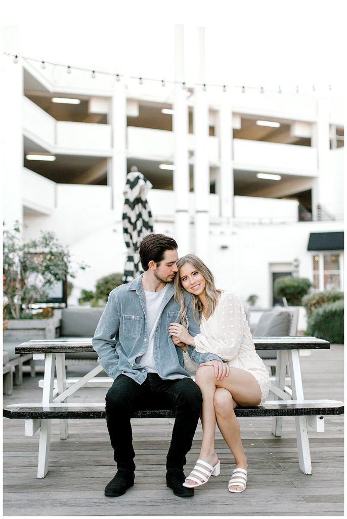 a couple sitting on a bench at a parking garage